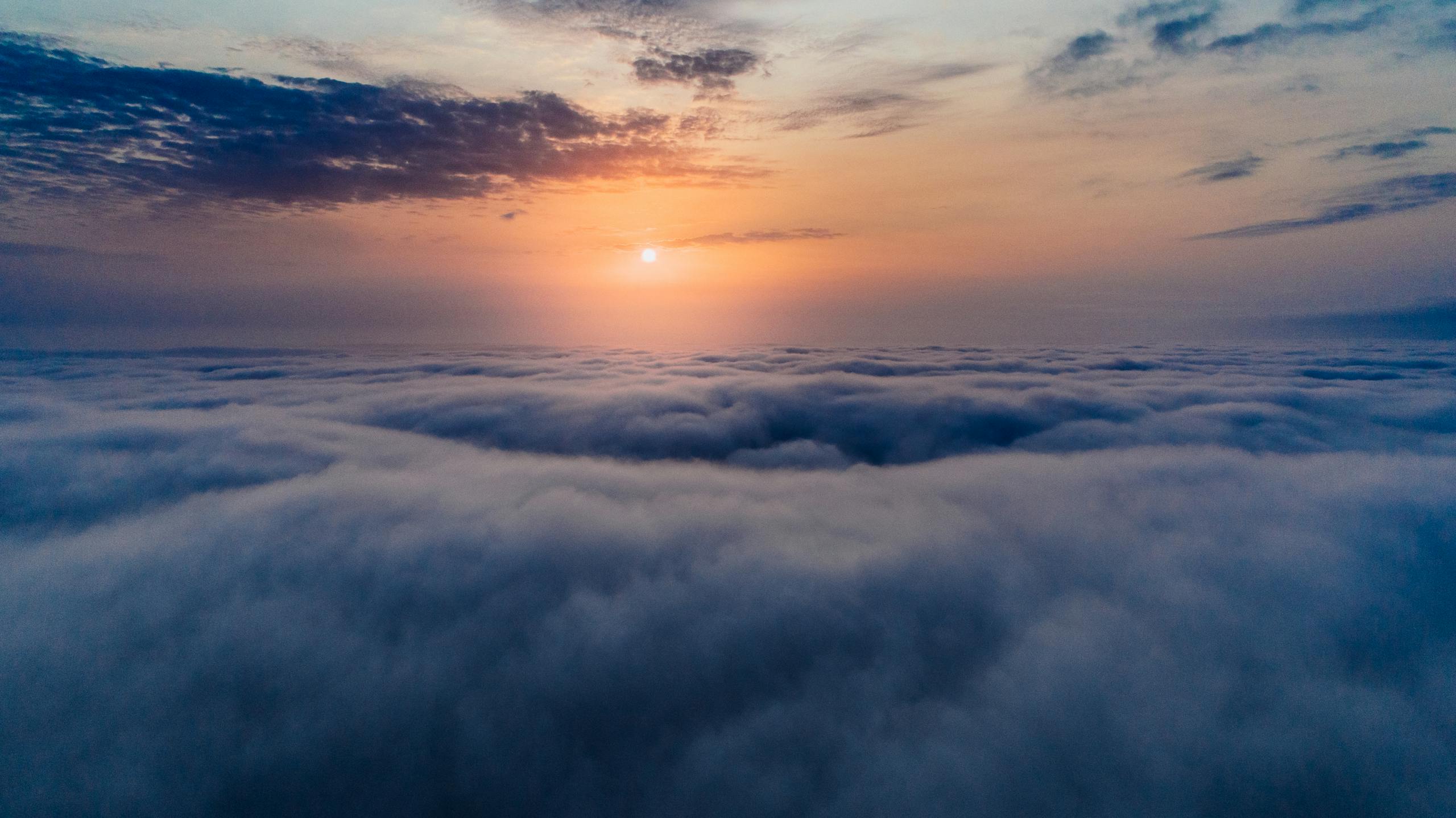 A stunning aerial view of sunrise over a vast cloudscape, capturing serene skies.