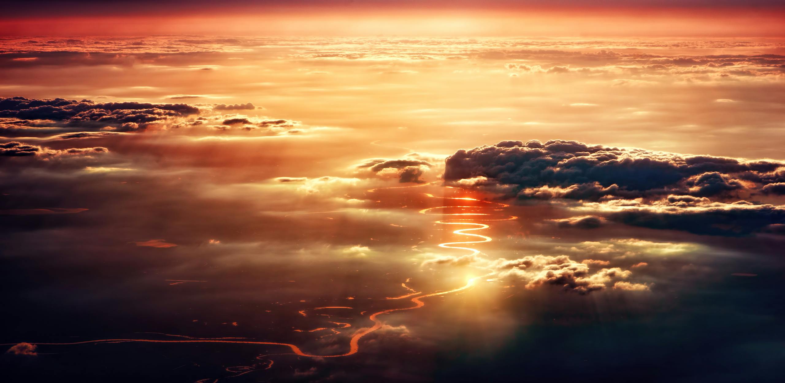 Breathtaking view of sunset reflecting on clouds with a serene river below.