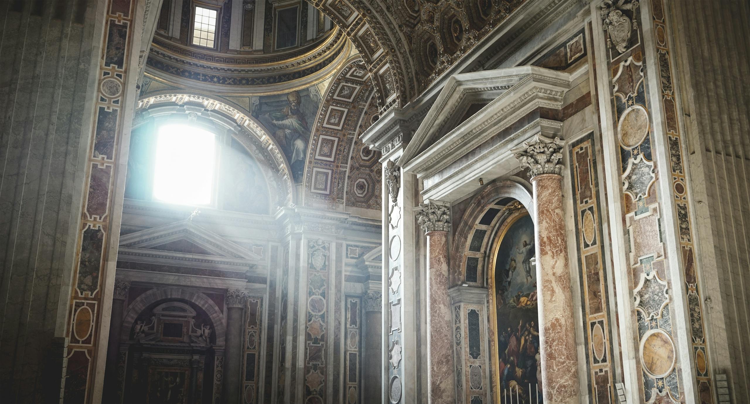 A majestic view of a cathedral's ornate interior with sunrays illuminating the columns.