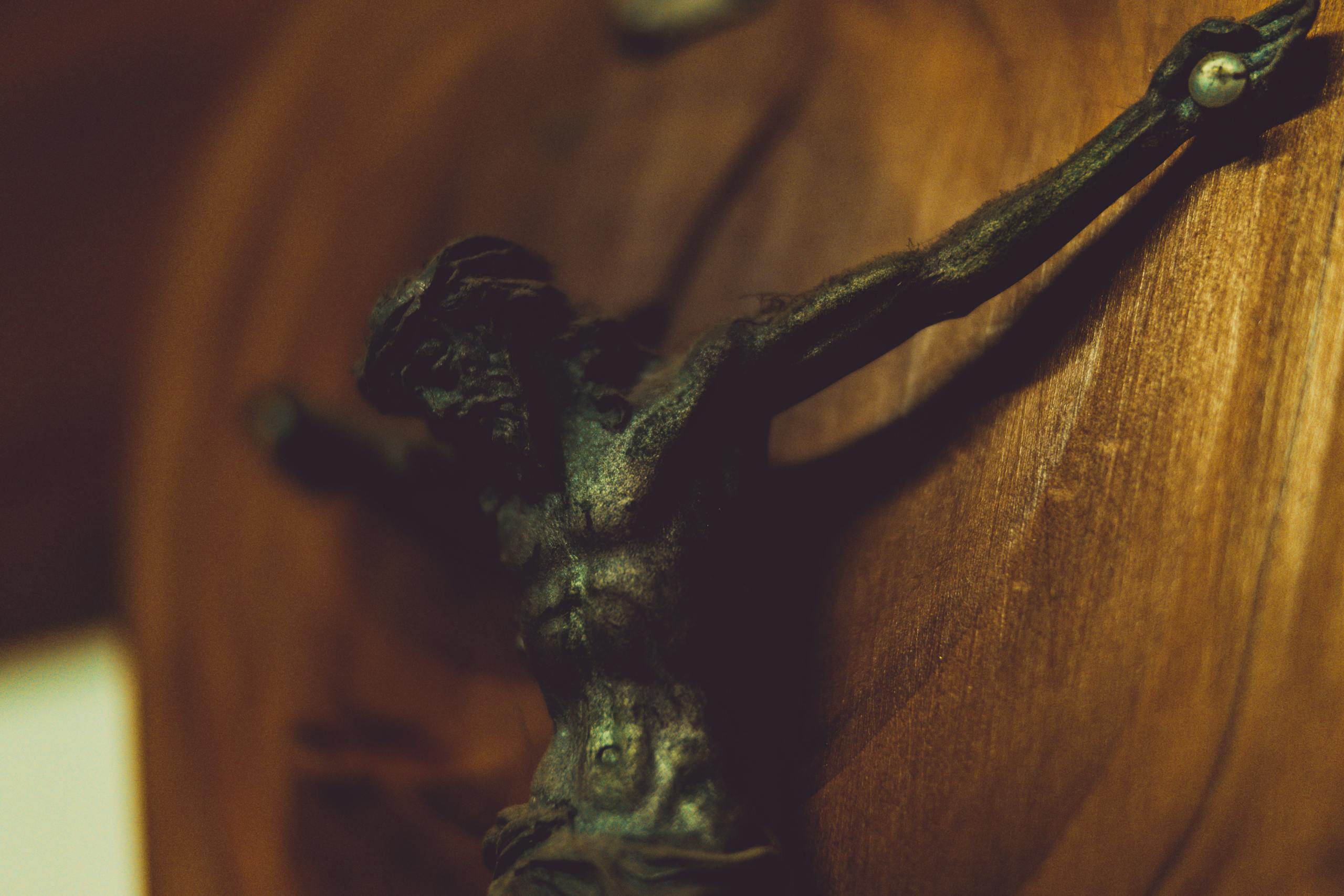 Detailed view of a wooden crucifix depicting Jesus Christ in warm tones.