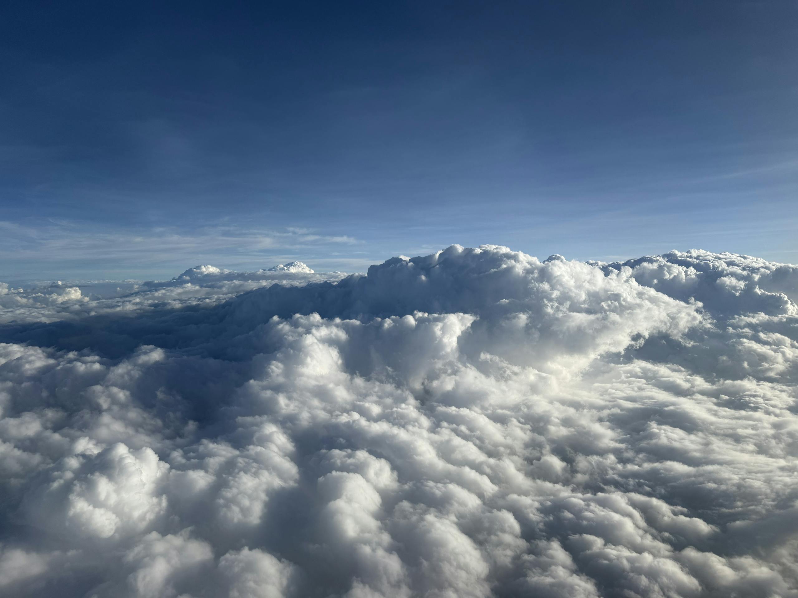 Aerial view of fluffy white clouds against a blue sky over India.